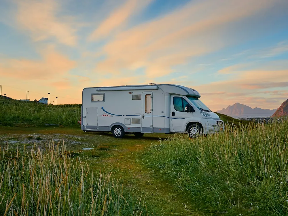 Autocaravana aparcada al atardecer junto a una montaña