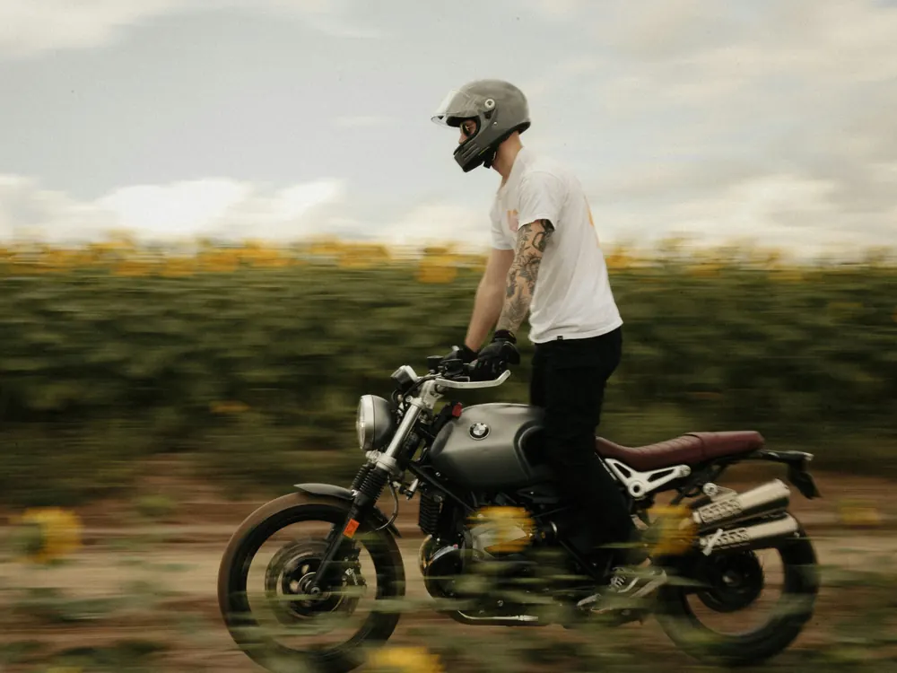 Motorista con casco sobre una BMW R nineT